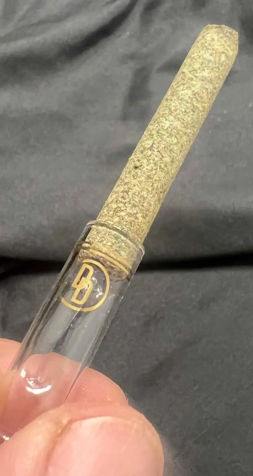 Close-up of the custom glass tip on a PURE prototype showing the gold DD Signature logo and gold bands